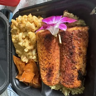 Honey Glazed Salmon sitting on yellow rice with yams and macaroni &amp; cheese