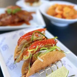Duck Tacos: House roasted duck, hoisin, apricot sweet chili, crispy gyoza skin | 2 pc-$14