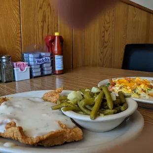 a plate of fried chicken with gravy and green beans