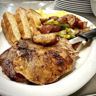 Breakfast Grilled Pork Chops with Home fries and toast.