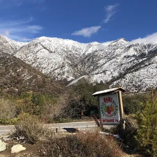 a sign in front of a mountain