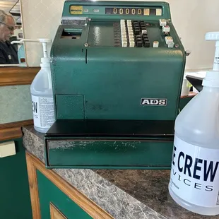 a cash register and a bottle of cleaner