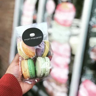 a person holding a bag of macarons