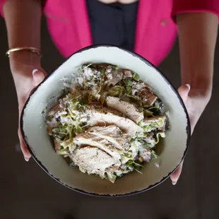 Lady holding her bowl of Pasta she built.