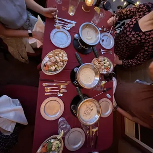 a group of people sitting at a table with plates of food