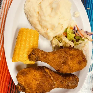 Chicken drumstick platter mashed potatoes corn and a side salad