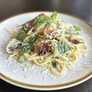 a plate of pasta with spinach and walnuts