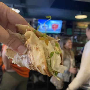 a hand holding a sandwich