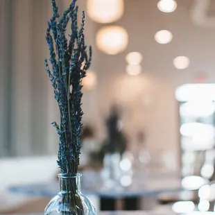 a glass vase with lavenders in it