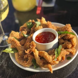 Popcorn Chicken a favorite among kids. Chicken breast marinated with fresh herbs coated with flour and fried with Thai basil leaves.