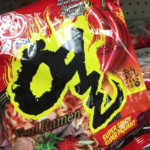 a hand holding a bag of ramen