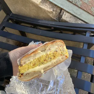 a person holding a sandwich in their hand