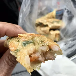 a hand holding a piece of food