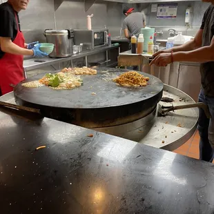 a man and a woman preparing food in a kitchen