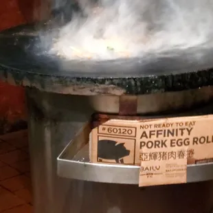 a person cooking food in a wok