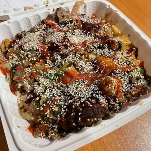 a white takeout container filled with food