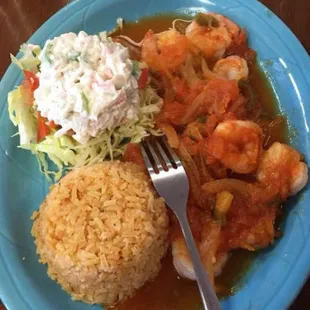a plate of food with shrimp, rice and coleslaw