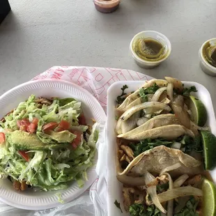 two plates of tacos and a salad