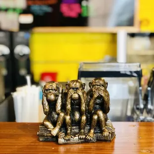 three monkeys sitting on a table