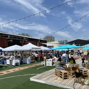 a large group of people sitting under blue umbrellas