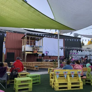 a group of people sitting under a large shade