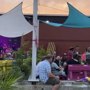 a group of people sitting on a bench in front of a stage