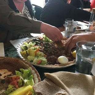 Combo share platter with lamb tips, fish tips, and chicken. Also comes with lentil, greens and salad.