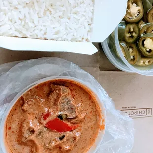 a bowl of white rice and a bowl of red curry