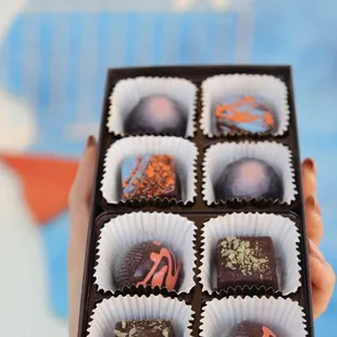 a hand holding a box of chocolates