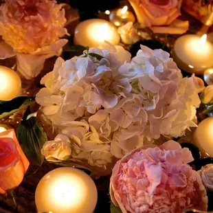 a bowl of flowers and candles