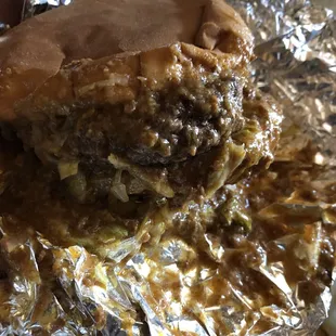 a closeup of a burger on aluminum foil