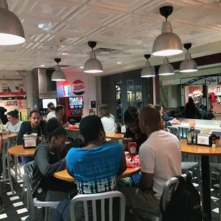 a group of people sitting at tables in a restaurant