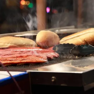 a hot dog being cooked on a grill