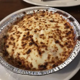 Baked spaghetti with pepperoni. Garlic cheese bread in the background