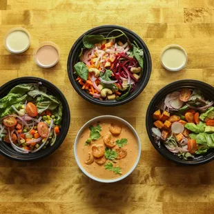 three bowls of food on a wooden table