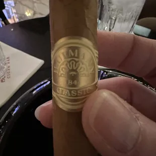 a hand holding a cigar