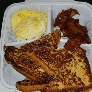 a breakfast of french toast, eggs and bacon