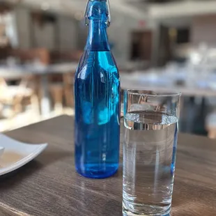 a blue bottle and a glass of water