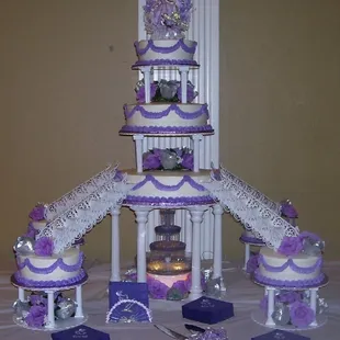 a tiered wedding cake with purple and white decorations