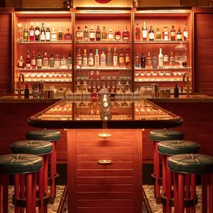 a bar with red couches and bar stools