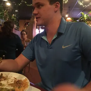 a man sitting at a table with a plate of food