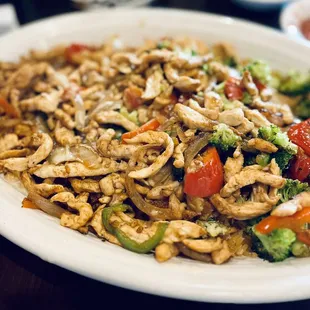 Arroz con Pollo w/ broccoli, peppers , and grilled onions. Served on bed of rice.