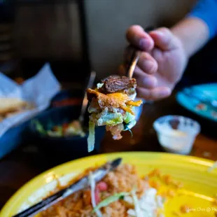 a person holding a fork over a plate of food