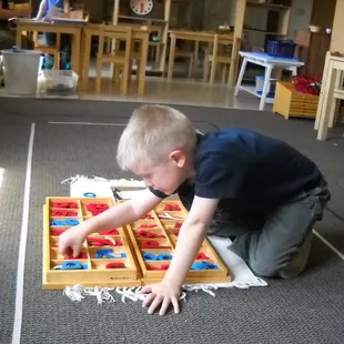 A young child learning how to spell using the moveable alphabet.
