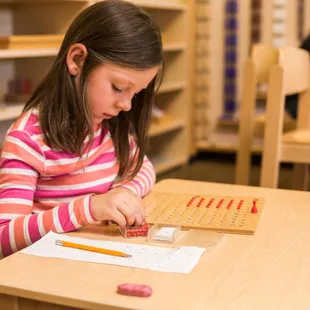 This preschool student is learning division with Montessori materials.
