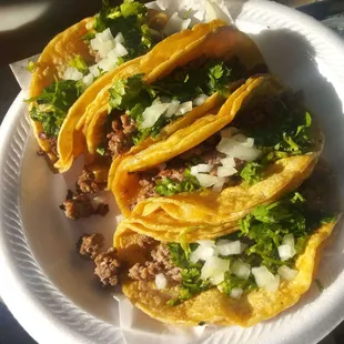 three tacos on a paper plate