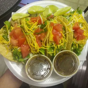Soft Corn Shell Tacos topped with Lettuce, Cheese, Tomato, Onion, and Cilantro.