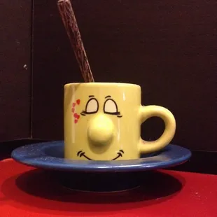 a coffee cup with a spoon sticking out of it