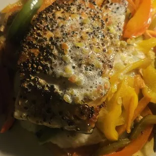 Salmon on a bed of vegetables and mashed potatoes