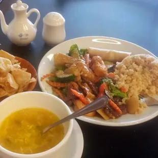 Lunch portion of Happy Family, Egg Drop Soup, mushy Fried Rice and spring roll with crispy Noodles and iced tea.